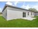 This home's backyard features lush green grass and a sliding glass door to the home's interior at 14915 Sw 39Th Cir, Ocala, FL 34473