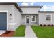 Inviting home entrance with a well-lit porch, lush green lawn, and a neatly paved walkway at 14915 Sw 39Th Cir, Ocala, FL 34473