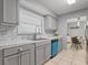 Gray kitchen features a stainless steel sink, mosaic backsplash, and bright natural light at 1514 Sparrow St, Longwood, FL 32750