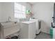 Bright laundry room includes washer, dryer, and utility sink at 1514 Sparrow St, Longwood, FL 32750