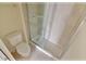 Tiled bathroom featuring a toilet and glass-enclosed shower at 16129 Palm Frond Ave, Clermont, FL 34714