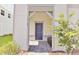 Inviting entryway featuring a covered porch, blue door, and fresh landscaping at 16129 Palm Frond Ave, Clermont, FL 34714