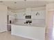 Modern kitchen with stainless steel appliances, island and white shaker cabinets at 16129 Palm Frond Ave, Clermont, FL 34714