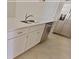 Close-up of kitchen island with a double sink, dishwasher and white cabinets at 16129 Palm Frond Ave, Clermont, FL 34714