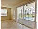 Open living area with tile flooring and sliding glass doors leading to a screened-in pool area at 16129 Palm Frond Ave, Clermont, FL 34714