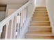A well-lit staircase with white banister and light wood treads at 16129 Palm Frond Ave, Clermont, FL 34714