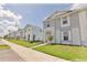 Street view of a residential neighborhood with sidewalks and a row of well-maintained townhomes at 16129 Palm Frond Ave, Clermont, FL 34714