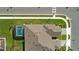 Bird's-eye view of a well-maintained home featuring a pool, manicured lawn, and paver driveway at 1650 Key Bay Trl, Kissimmee, FL 34747