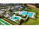 Aerial view of a community clubhouse featuring two pools, cabanas, and lush landscaping surrounded by palm trees at 1650 Key Bay Trl, Kissimmee, FL 34747