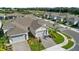 An elevated view of a home with a two car garage, paver driveway, and a well-maintained landscape at 1650 Key Bay Trl, Kissimmee, FL 34747