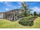 Manicured backyard with a screened-in pool, lush landscaping, and tranquil outdoor space for relaxing at 1650 Key Bay Trl, Kissimmee, FL 34747