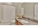 Cozy bathroom highlighting a granite countertop vanity, toilet, and a shower with a white curtain at 1650 Key Bay Trl, Kissimmee, FL 34747