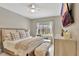 Bright bedroom with a large bed, ceiling fan, TV, and a cozy seating area near the window at 1650 Key Bay Trl, Kissimmee, FL 34747