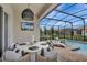 Enclosed patio featuring a dining table, grill, and lounge chairs beside a sparkling swimming pool at 1650 Key Bay Trl, Kissimmee, FL 34747