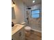 Updated bathroom with modern vanity, toilet, and shower featuring marble tile and black fixtures at 2035 Voltaire St, Lakeland, FL 33801