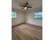 Bright bedroom featuring wood-look flooring, a ceiling fan, and two windows offering natural light at 2035 Voltaire St, Lakeland, FL 33801