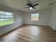 Bright bedroom featuring wood-look floors, natural light, ceiling fan and mini-split air conditioner at 2035 Voltaire St, Lakeland, FL 33801
