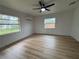 Bright bedroom features wood floors, ceiling fan, and two windows allowing natural light at 2035 Voltaire St, Lakeland, FL 33801