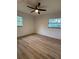 Bright bedroom featuring wood-look flooring, a ceiling fan, and two windows offering natural light at 2035 Voltaire St, Lakeland, FL 33801