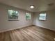 Bright bedroom with wood-look flooring, fresh paint, and multiple windows, creating an airy atmosphere at 2035 Voltaire St, Lakeland, FL 33801