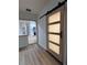 Hallway with updated floors, neutral paint, and view of the kitchen and a modern barn door at 2035 Voltaire St, Lakeland, FL 33801