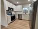 Updated kitchen features stainless steel appliances, quartz countertops, and modern cabinetry, for gourmet cooking at 2035 Voltaire St, Lakeland, FL 33801