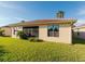 View of the backyard featuring lush grass and the exterior of the home at 223 Monterey St, Kissimmee, FL 34759