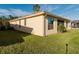 Back exterior view of a home with green grass and a screen lanai at 223 Monterey St, Kissimmee, FL 34759
