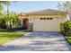 Charming home featuring a tile roof, stone accents, a two-car garage, and a well-manicured lawn at 223 Monterey St, Kissimmee, FL 34759