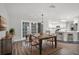 Dining area with wooden table and chairs, seamlessly connecting to the modern, all-white kitchen at 229 Marcum Trace Dr, Lakeland, FL 33809
