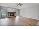 Inviting living room with a stone fireplace, hardwood floors, and ample natural light from large windows at 229 Marcum Trace Dr, Lakeland, FL 33809