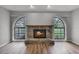 Cozy living room showcases a stone fireplace, wood floors, and arched windows at 229 Marcum Trace Dr, Lakeland, FL 33809