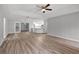 Open-concept living room with hardwood floors and neutral paint, seamlessly connecting to the kitchen at 229 Marcum Trace Dr, Lakeland, FL 33809