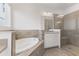 Bright bathroom featuring a soaking tub, shower, and vanity with modern fixtures and neutral tile at 2292 Sirena Ln, Mount Dora, FL 32757