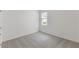A bedroom with neutral carpet, a single window, and freshly painted, light neutral walls at 2292 Sirena Ln, Mount Dora, FL 32757