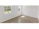 A bright bedroom with tile floors and two windows overlooking a green and well-maintained lawn at 2292 Sirena Ln, Mount Dora, FL 32757