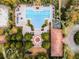Aerial view of community pool and clubhouse showcasing lounge chairs, a playground, and lush green trees at 2313 Pesaro Cir, Ocoee, FL 34761