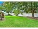 Expansive backyard features a white fence, mature trees, and lush green grass at 2313 Pesaro Cir, Ocoee, FL 34761