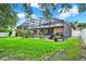 A spacious, screened-in pool and patio seamlessly blend with the grassy backyard at 2313 Pesaro Cir, Ocoee, FL 34761