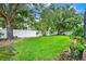 Spacious backyard featuring lush green grass, a white vinyl fence, and mature trees, perfect for outdoor activities at 2313 Pesaro Cir, Ocoee, FL 34761