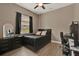 Comfortable bedroom featuring hardwood floors, a modern ceiling fan, and a window with black curtains at 2313 Pesaro Cir, Ocoee, FL 34761