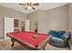 Bright game room features a pool table, a ceiling fan, and a comfortable lounging area at 2313 Pesaro Cir, Ocoee, FL 34761