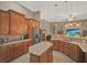 Open kitchen includes stainless refrigerator, custom cabinets, granite countertops, large island and breakfast bar at 2313 Pesaro Cir, Ocoee, FL 34761