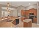 Spacious kitchen featuring granite countertops, custom cabinets, an island, breakfast bar, and pendant lighting at 2313 Pesaro Cir, Ocoee, FL 34761