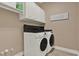 Bright laundry room features a washer and dryer, with white cabinets for storage at 2313 Pesaro Cir, Ocoee, FL 34761