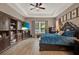 Spacious main bedroom featuring a tray ceiling, hardwood floors, and large wooden entertainment center at 2313 Pesaro Cir, Ocoee, FL 34761