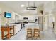 Bright kitchen featuring white cabinets, modern appliances, and a cozy island seating area for casual dining at 2520 Nw 53Rd Avenue Rd, Ocala, FL 34482