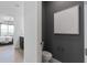 Stylish half-bathroom featuring a modern toilet, decorative artwork, and a glimpse into a beautifully decorated bedroom at 2757 Redblush Ter, St Cloud, FL 34772