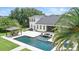 An aerial view of a backyard featuring a luxurious pool, hot tub, covered dining area, and tropical landscaping at 2908 Lee Shore Loop, Orlando, FL 32820
