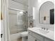 Bathroom with white cabinets, tiled shower with glass door and a large mirror at 2908 Lee Shore Loop, Orlando, FL 32820